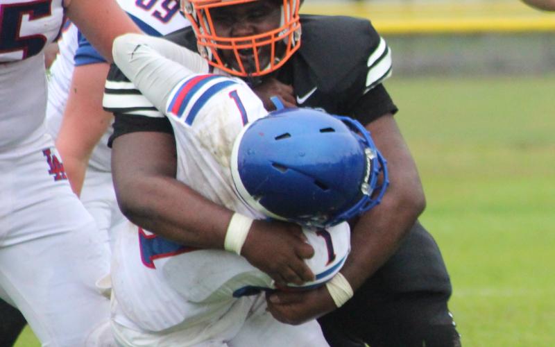 A Pine Prairie defensive player wraps up a Lake Arthur offensive player during the team’s scrimmage played last week in Pine Prairie. (Gazette photo by Rhett Manuel)