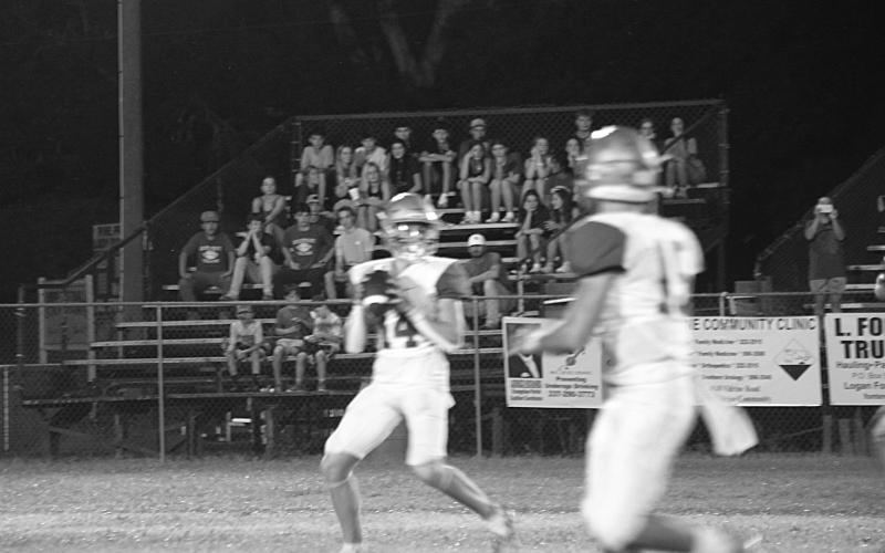 Trojan quarterback Hayden Droddy (14) looks to complete a pass to a target in the jamboree. Sacred Heart now hosts Ville Platte High in the Tee Cotton Bowl tomorrow night at Soileau-Landry Field. (Gazette photo by Sylis Manuel)