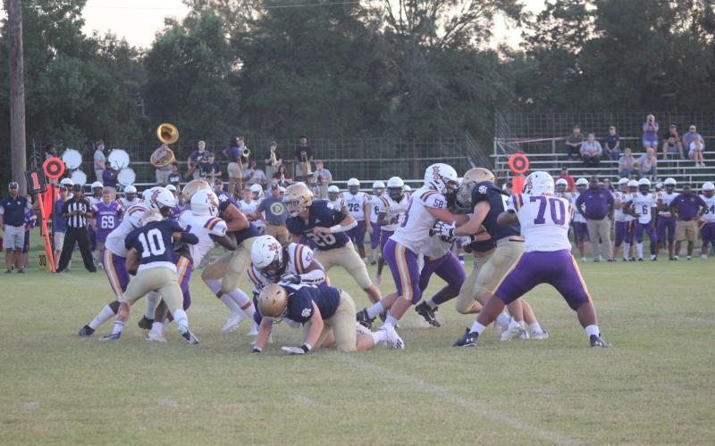 The stout Sacred Heart defensive unit combines to make a stop in the Trojans’ 35-7 win over Marksville last week. The Trojans now host parish rival Basile at Soileau-Landry Field in a Week 3 matchup. (Gazette photo by Rhett Manuel)