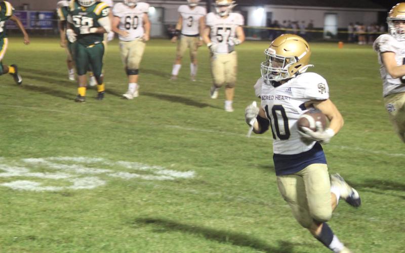 Sacred Heart’s Blake Hebert (10) picks up yardage on his career rushing night as the Trojans earned a 57-0 win over Mamou. (Gazette photo by Rhett Manuel)