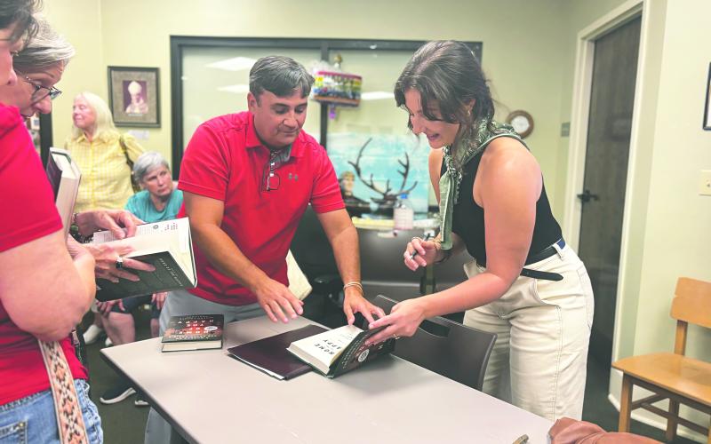LARGE TURN OUT FOR BOOK SIGNING - Local author Jordan LaHaye Fontenot (right) signs copies of her new novel for David LaHaye. (Gazette photo by Heather Bogard)