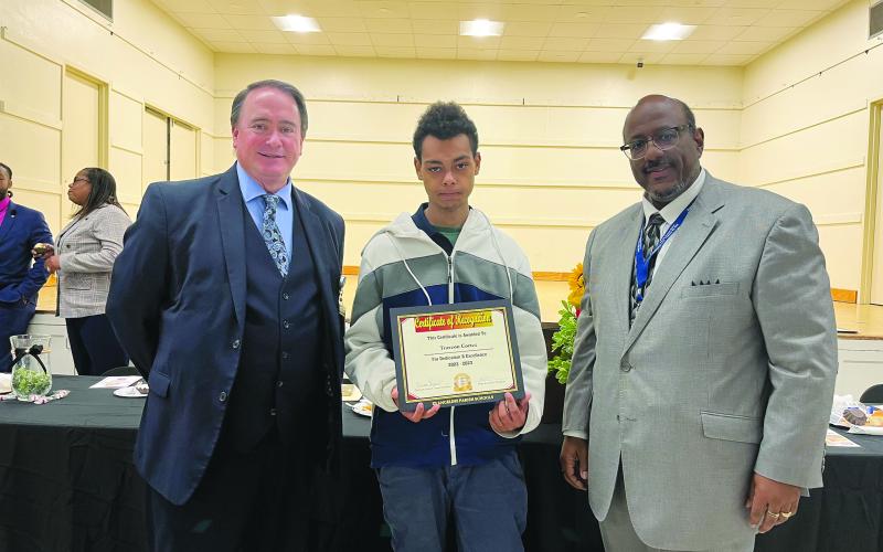 OUTSTANDING WORK-BASED STUDENT OF THE YEAR RECOGNIZED - Traveon Cortez of Basile High School, who worked at Rhea’s Specialty Meats in Baslie, was announced as the Outstanding Work-Based Student of the Year during the annual appreciation luncheon held Thursday, March 16. He is shown with Assistant Superintendent Mike Lombas (left) and Superintendent Darwan Lazard (right). (Gazette photo by Heather Bogard