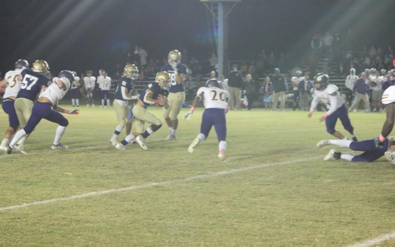 Sacred Heart starting quarterback Caleb Hood (3) tries to find a running lane in the Trojans’ 14-6 home loss to Opelousas Catholic. (Gazette photo by Rhett Manuel)