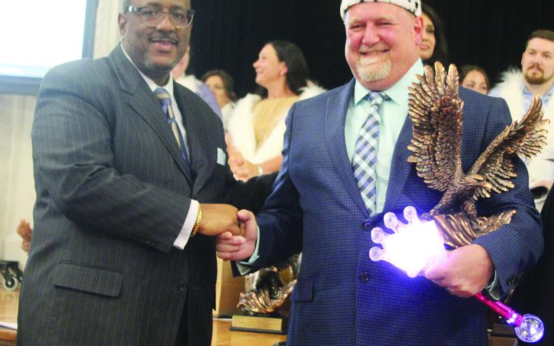 Superintendent Lazard (left) shares a handshake with Tim Comeaux (right). Comeaux is the district’s middle school teacher of the year and a state semi-finalist. (Gazette photo by Tony Marks)