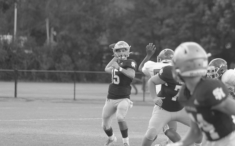 Wade Pitre (15) delivers a pass for Sacred Heart against Bunkie in a pre-season scrimmage. In Week 3, against Basile, he delivered pass to Hayden Droddy for 21 yards and a touchdown as time expired to put his Trojans at 3-0 on the season. (Gazette photo by Tony Marks)