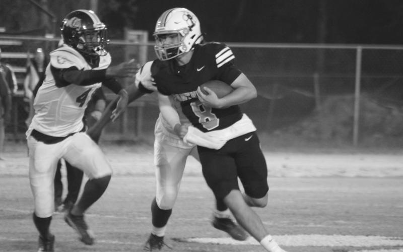 Panther quarterback Branson Fontenot (8) tries to avoid a tackle from a Bulldog defensive player in Pine Prairie’s home 34-13 loss Thursday night. (Gazette photo by Rhett Manuel))