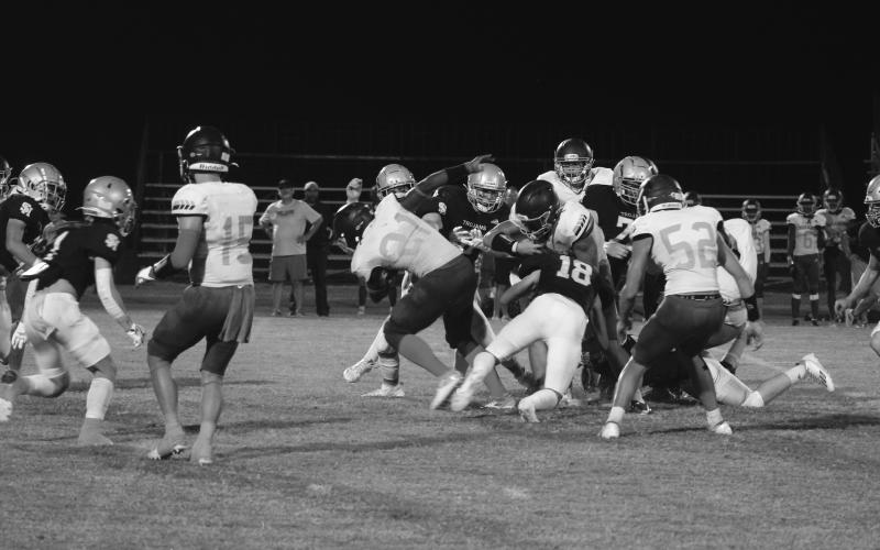 Abram Manuel (18) and others on the Sacred Heart defense combine for a stop against Westminster in the Trojans’ 31-24 home loss Thursday night. (Gazette photo by Tony Marks)