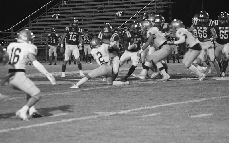 The Sacred Heart defense, with Bradley Fusilier (2), combines for a stop against St. Edmund in a 30-17 win by the Trojans. (Gazette photo by Rhett Manuel)
