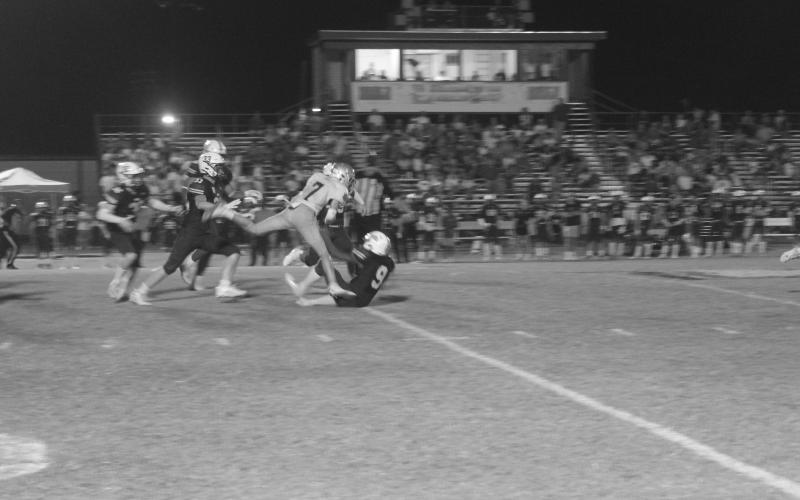 A banged up Hayden Droddy (7) fights for yardage after getting tripped up by several Eagles from Holy Savior Menard. Droddy and the rest of his Sacred Heart Trojans moved to 4-0 after a 20-0 win Friday night. (Gazette photo by Tony Marks)