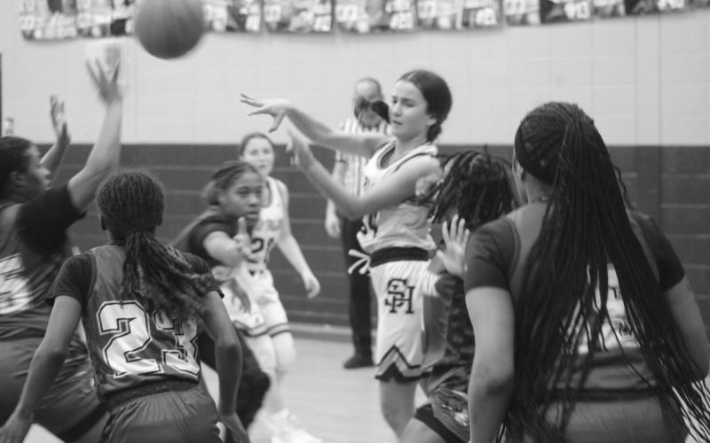 Riley St. Cyr (34) looks to get rid of the basketball while being swarmed by a pack of Lady Bulldogs on Tuesday, January 28. (Gazette photo by Tony Marks)