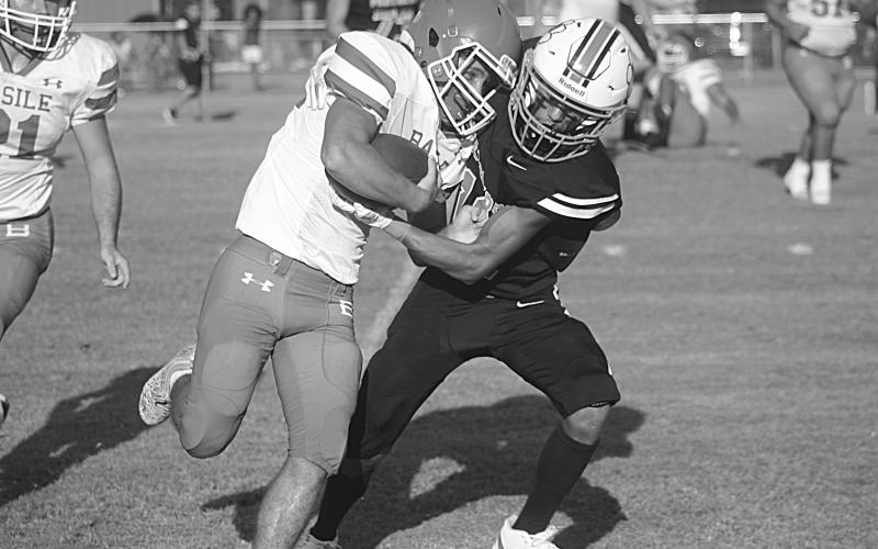 Pine Prairie’s Jayland Duplechin (13) looks to bring down Basile’s Logan Bergeron (22) in the first game of the jamboree. (Gazette photo by Tony Marks)