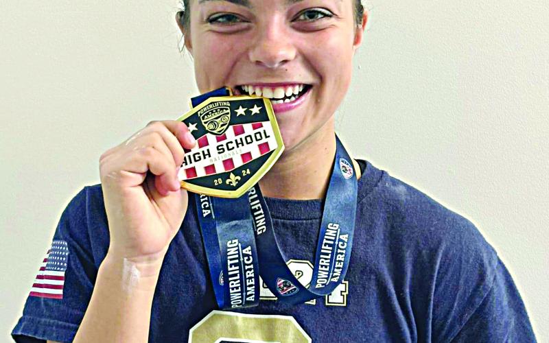 Adeline Launey shows off her medal for winning a national powerlifting meet in New Orleans. (Photo courtesy of Sacred Heart Athletics)