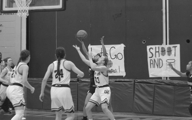 Members of the Lady Trojan basketball team watch as Jodie Landry (23) tries to steal the basketball from a Lincoln Prep player. The team now hosts St. John, of Plaquemines, with a trip to the state tournament on the line. (Gazette photo by Rhett Manuel)