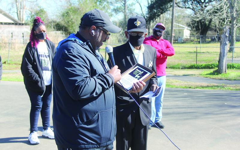 Reverend Darwan Lazard of Ninth Baptist Church (left) reads a plaque being presented to Brother Eldridge Thomas (right) in memory of his late wife, Barbara. (Gazette photo by Tony Marks)