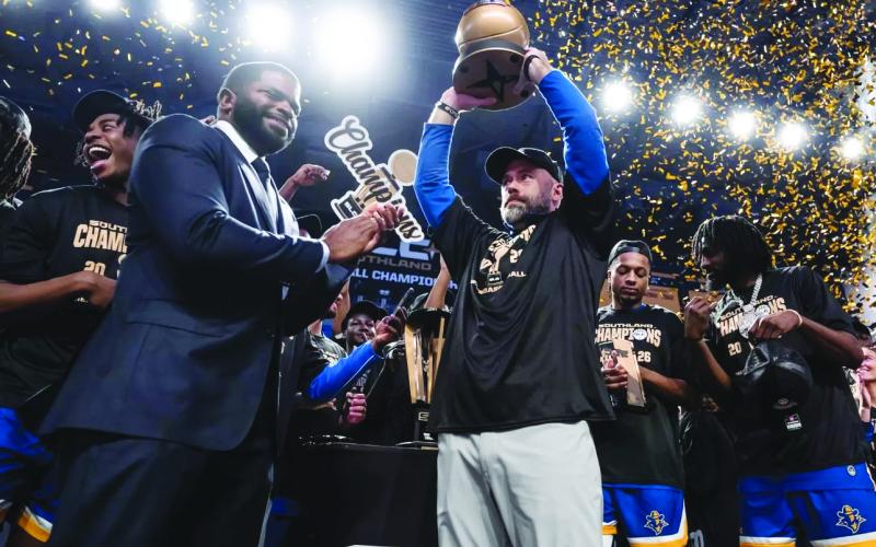McNeese head men’s basketball coach Bill Armstrong (center) hoists the SLC Championship Trophy after the Cowboys defeated Stephen F. Austin. (Photo courtesy of Matthew Bonnette)