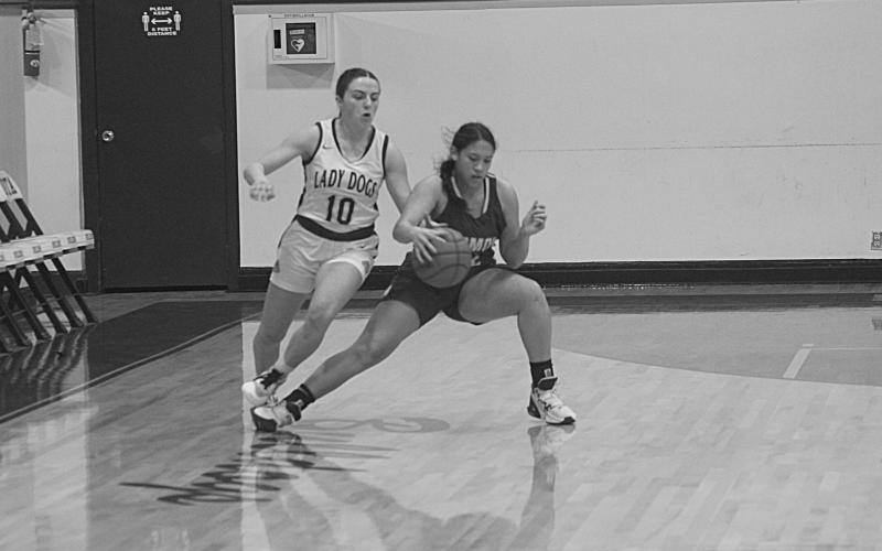 Maddie Fontenot (right) dribbles past an Iota defender in the Mamou Lady Green Demons’ 60-30 loss Thursday night. (Gazette photo by Rhett Manuel)