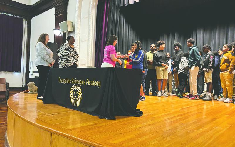 ERA seventh grader Majesty Soileau (right) receives her Evangeline Chamber of Commerce membership card from Chamber member Kristi Enicke as fellow members Trina Orgeron (left) and Linda Fontenot look on. (Gazette photo by Heather Bogard)