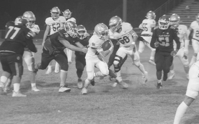 Jude Hebert (23) finds running room for his Sacred Heart Trojans in their 42-6 win over North Central Thursday night. (Gazette photo by Rhett Manuel)