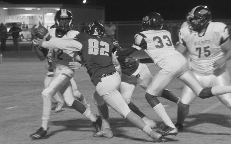 Ville Platte’s Braylin Griffin (12) attempts to get rid of the football before being taken down by Oberlin’s Kadyn Dart (82) in the regular season finale last Friday night. (Gazette photo by Rhett Manuel)
