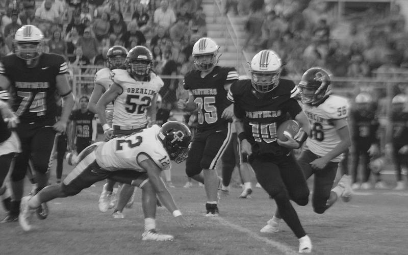 Cayden McCollough (10) runs past a diving Adarius Botley (12) and Mason Hazelton (56) from Oberlin. (LSN photo by Tony Marks)
