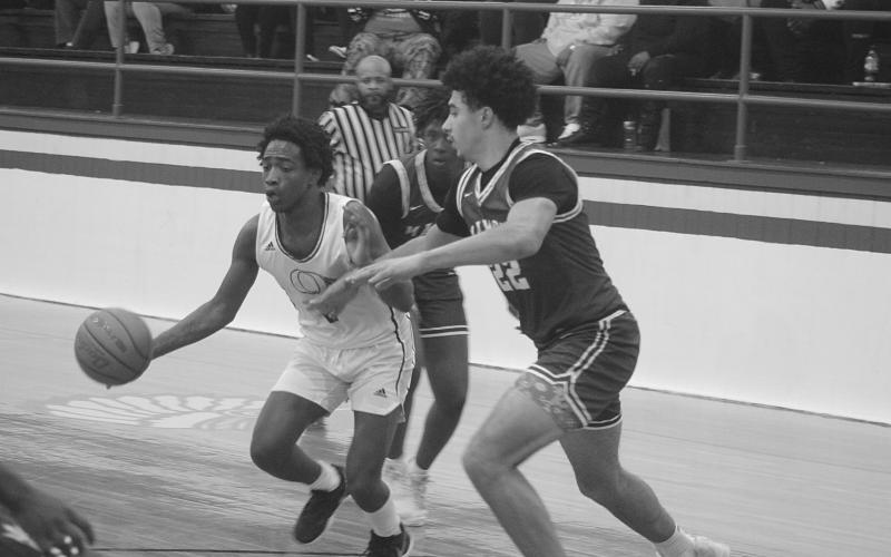 Mamou’s Shay Collins defends against Oakdale’s Leon Posey V (2) in the Green Demons’ 65-63 win against the Warriors last Friday night. (Gazette photo by Tony Marks)