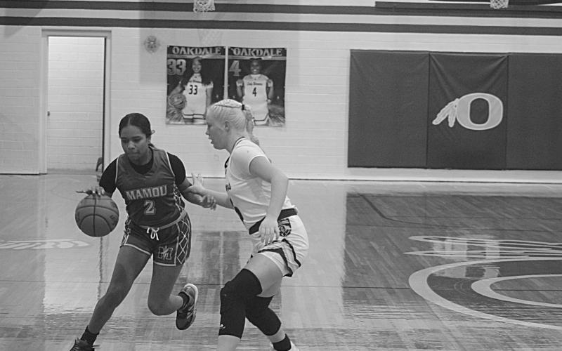 Jaiden Richard (2) brings the basketball down the court and around Oakdale’s Jolie West (15). (Gazette photo by Tony Marks)