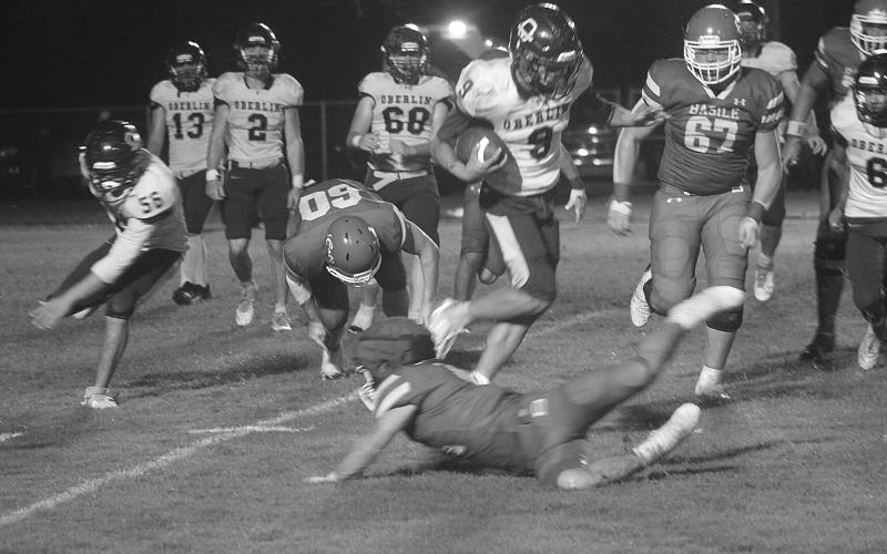 A diving Pierson Comeaux (14) attempts to make a tackle on a leaping Jayden Bokemeyer (9) during Basile’s 26-0 win over Oberlin on Halloween night. (Gazette photo by Tony Marks)