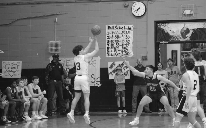 Gabe Fontenot (3) shoots the basketball from beyond the arc. Fontenot’s Trojans closed out the game with a win  before ending the season with a loss against Southern Lab in the second round of the playoffs. (Gazette photo by Tony Marks)