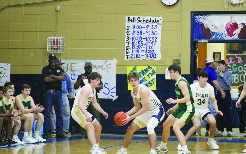Karson Vidrine (12) plants his feet in order to protect the basketball in the Trojans playoff opening win against Ouachita Christian on Friday, February 23. (Gazette photo by Tony Marks)