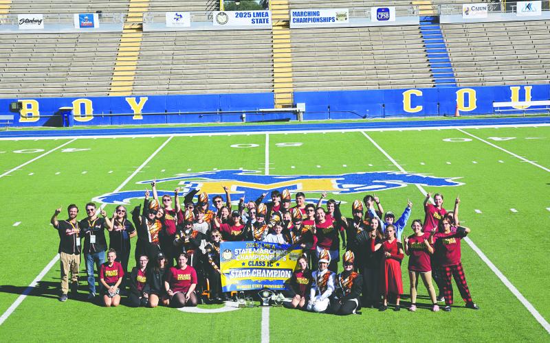 The Pine Prairie High School Marching Band recently ended their season on a high note by capturing  the LMEA State Championship for second year in a row. The group, in the above photo, gathers around the championship banner. (Photo courtesy of Lynette Hazelton)