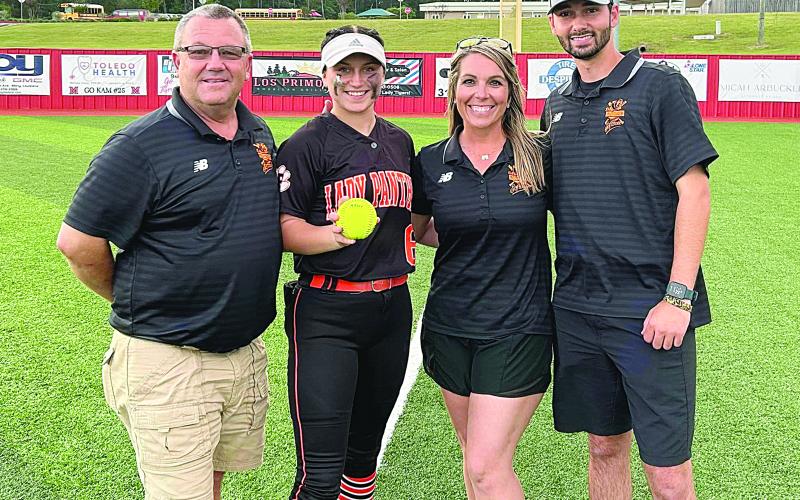 Pine Prairie Lady Panther Camron Lafleur delivered a two-run home run in the top of the seventh inning that sent her team past Many and into the quarterfinal round against the winner of the game between Sterlington and Pine. From left are assistant coach Craig Whittington, Lafleur, head coach Alycia Hebert, and assistant coach Hunter Arnaud. (Photo courtesy of Pine Prairie High School Softball)