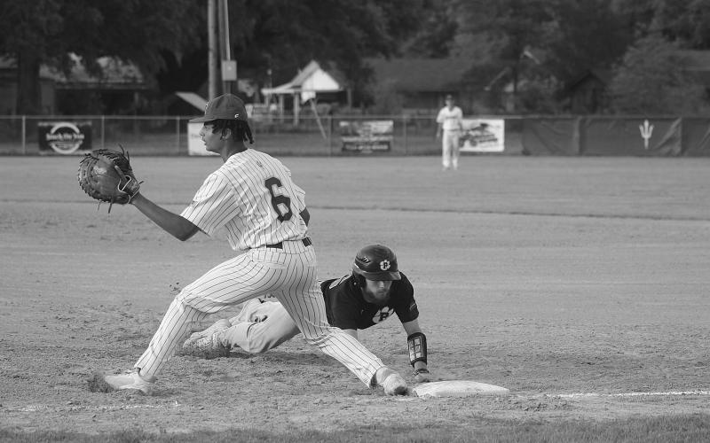 Mamou’s Ian Tezeno (6) attempts to make a play as Pine Prairie’s Kyle Basco (16) slides back safely at first base. (Gazette photo by Tony Marks)