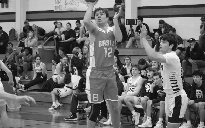 Basile’s Sy Boenig (12) is able to attempt a basket despite being guarded by Sacred Heart’s Cole Tate (11).