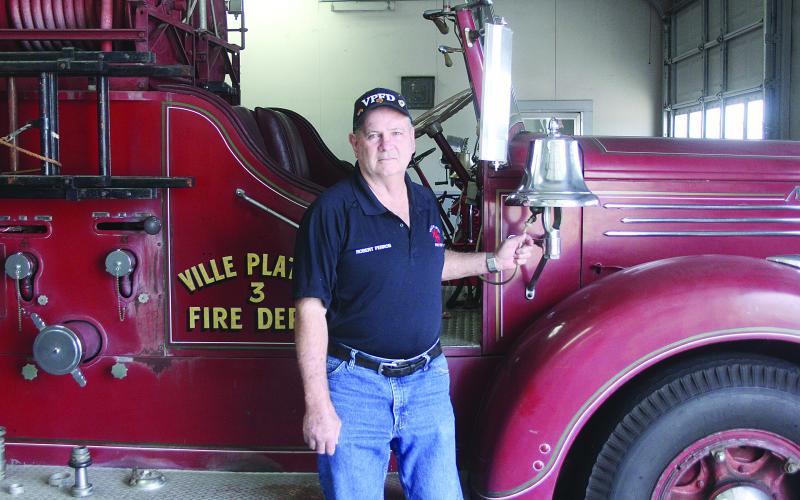 Robert Perron, a 50-year veteran of the Ville Platte Fire Department, is pictured as he rings he bell on fire truck No. 3. (Gazette photo by Tony Marks)