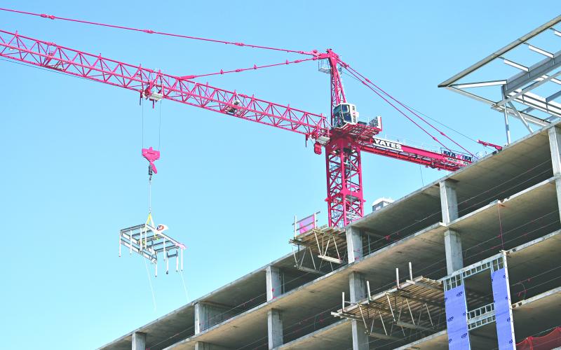 In the right photo, the crane operator helps lower the scaffolding into position. (LSN photos by Rebekah Ogea)
