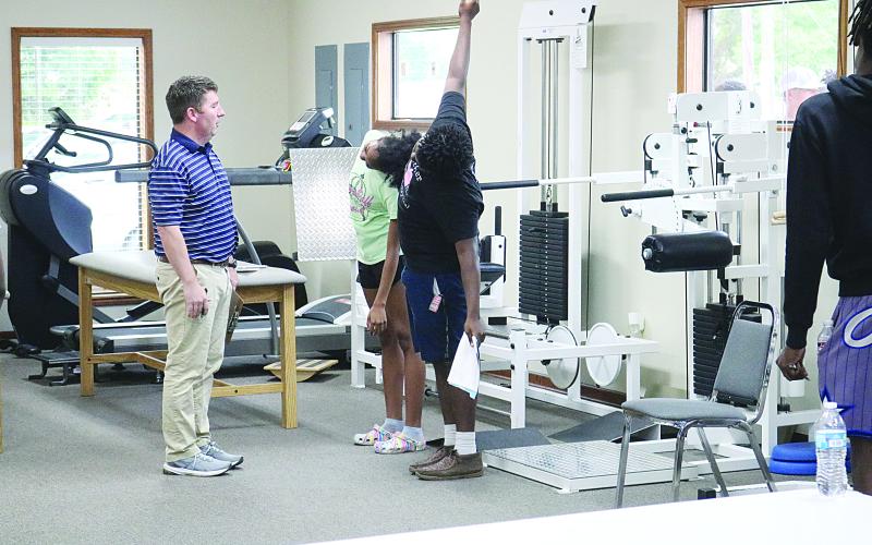 Physical therapist Clay Landreneau (left) checks range of motion on two athletes from Ville Platte High, including Kyle Gallow (right).