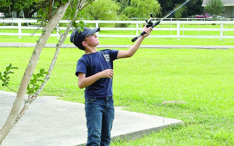 Liam Darbonne, son of Paula and Mayor Justin Darbonne, of Chataignier, casts his line into the village’s fishing pond. (Gazette photo by Tony Marks)