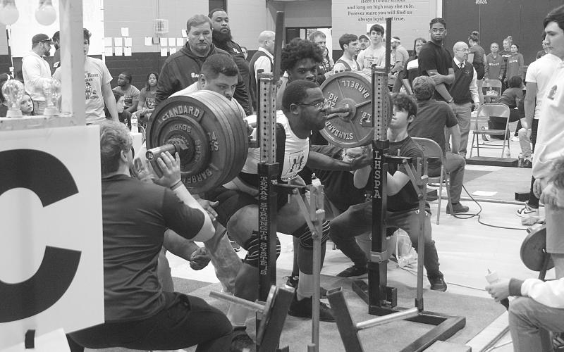 Alex Dick, of Mamou High School, squats in the Sacred Heart Invitational. His best mark in the event was 585 pounds, and his total mark on the day in all three events was 1,450 pounds. (Gazette photo by Tony Marks)