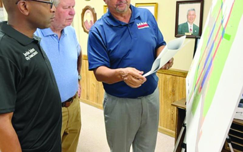 Purvis Morrison (right) reviews a map depicting areas of the proposed land use policy. Also pictured are Councilmen Mike Perron (center) and Jordan Anderson (left). (Gazette photo by Tony Marks)