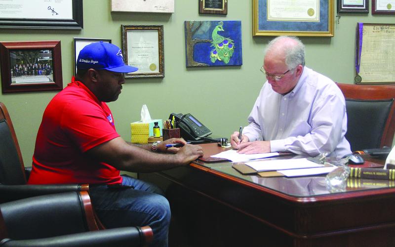 Evangeline Parish Clerk of Court Randy Deshotel (right) notarizes paperwork for Ryan Leday Williams (left), who was the first candidate to qualify for the November election. (Gazette photo by Tony Marks)