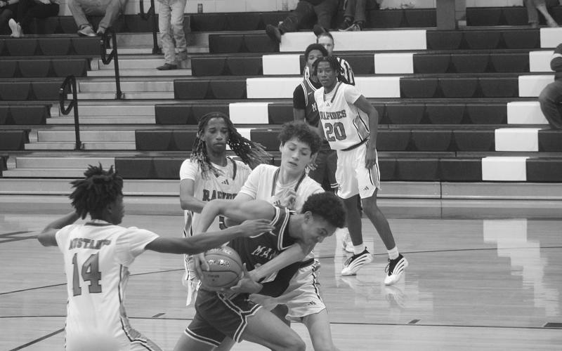 Braxton Ardoin (11) fights through traffic to collect a basket for Mamou in the Green Demons’ 70-40 win over Rapides last season. (Gazette photo by Tony Marks)