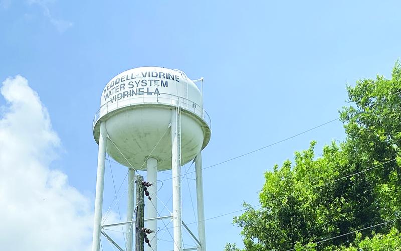 Pictured in the main photo is the Reddell-Vidrine Water System water tower. Pictured in the inset photo is Elizabeth Yvette Jagneaux, a former teacher in Evangeline Parish who worked with Communities Unlimited to restore and rebuild the water system. (Photos courtesy of Communities Unlimited and Elizabeth Jagneaux)