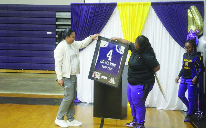Ville Platte Lady Bulldog head coach Rhonda Thomas (right) presents a framed jersey to her former high school teammate Renotta Edwards (left). Edwards’ jersey is now retired and is on display in the school’s trophy case. (Gazette photo by Tony Marks)