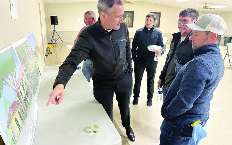 Fr. J. Patrick Hough, S.J., the new executive director of Grand Coteau Retreats, is pictured on the left as he points out proposed renderings of the new master plan of Our Lady of the Oaks Retreat House and St. Charles College. Also pictured, from left, are Fr. Alex Lançon, parochial vicar of Sacred Heart of Jesus Catholic Church; Mickey Johnson; and Jay Johnson. (Gazette photo by Tony Marks)