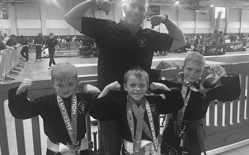 STUDENTS DO WELL IN TOURNAMENT - Standing in front, from left, Inner Game Jiu-Jitsu students Ian Mire, Weston Fontenot and Charlie Stevens excelled in a recent tournament held in New Orleans. They are shown with their proud coach Robbie Stevens, standing in back. (Photo courtesy of Robbie Stevens)