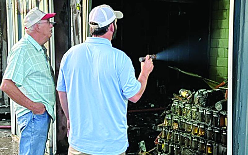 Kary LaFleur (left) and son, Ross, inspect the damage caused by a fire at Kary’s Roux in Ville Platte. According to Fire Chief Chris Soileau, the cause of the fire remains under investigation. (Gazette photo by Tony Marks)