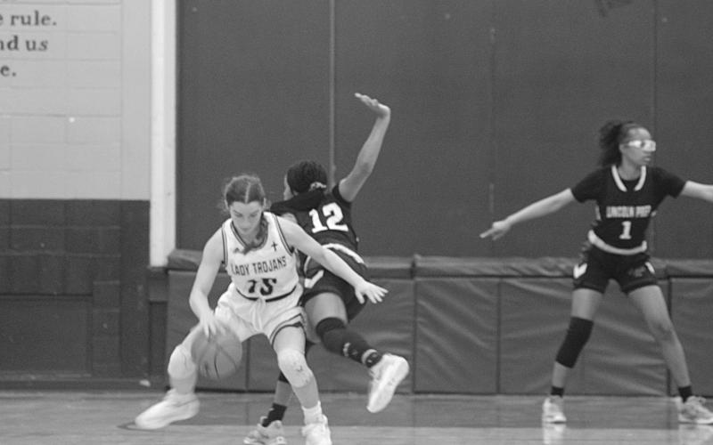 Ava Johnson (15) spins around a Lincoln Prep defender in Sacred Heart’s 58-21 disposal of the Lady Panthers in the opening round of the Select Division IV playoffs. The Lady Trojans now travel to Delta Charter for their second round matchup on Monday. (Gazette photo by Rhett Manuel)