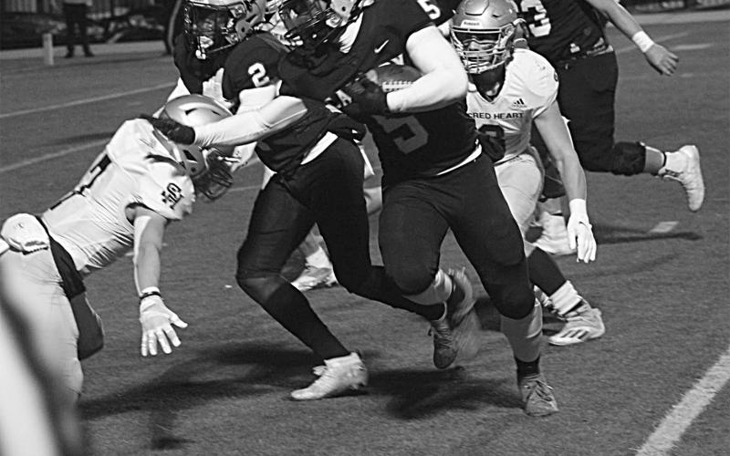 The Sacred Heart defense combines for a stop against Calvary Baptist in the Trojans’ quarterfinal loss, 63-7, in Shreveport Friday night. (Gazette photo by Rhett Manuel)