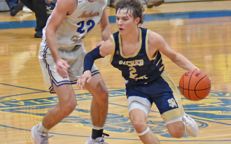 Sacred Heart’s Gabe Fontenot (2) dribbles the ball down the court in the Trojans’ season opening win against Northside Christian in Crowley. Fontenot scored 17 points on the night. (LSN photo by Chris Quebedeaux)