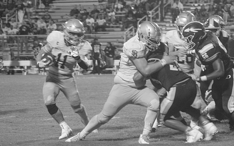 Ashton Duos (11) looks to turn a corner and pick up positive yardage in Sacred Heart’s regular season opening win against Oakdale, 32-0. (Gazette photo by Tony Marks)